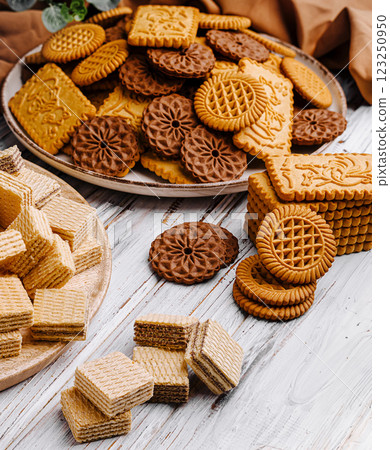 Assorted cookies piled on plates for a delightful dessert spread 123250950