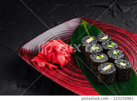 Fresh sushi rolls served with pickled ginger on a vibrant plate Fresh sushi rolls served with pickled ginger on a vibrant plate 123250961