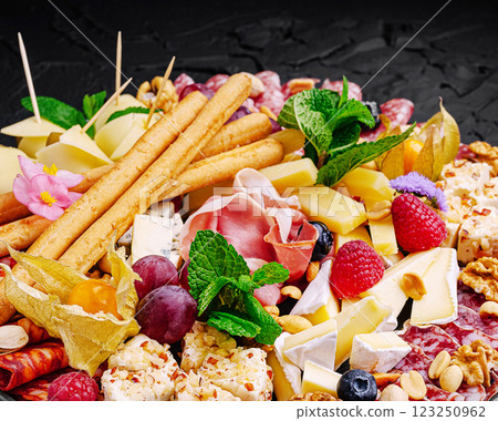 Tasty cheese and charcuterie board with fresh fruits and herbs 123250962
