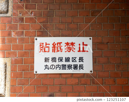 A notice prohibiting postings was posted on the wall of a road crossing under a railway overpass. 123251107