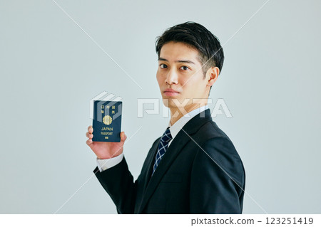 一名二十多歲的年輕人拿著護照 一名二十多歲的年輕人拿著護照 123251419