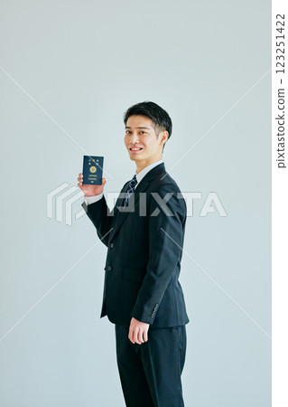 一名二十多歲的年輕人拿著護照 一名二十多歲的年輕人拿著護照 123251422