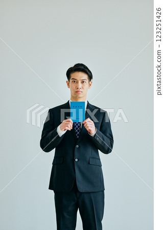 一名 20 多歲的年輕人拿著一本退休金簿 123251426