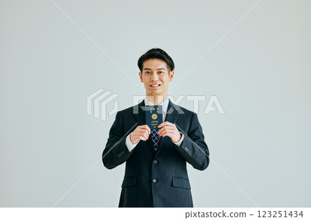 一名二十多歲的年輕人拿著護照 一名二十多歲的年輕人拿著護照 123251434