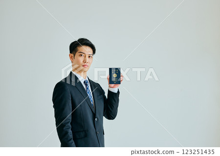 一名二十多歲的年輕人拿著護照 一名二十多歲的年輕人拿著護照 123251435