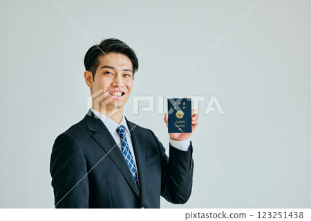 一名二十多歲的年輕人拿著護照 一名二十多歲的年輕人拿著護照 123251438