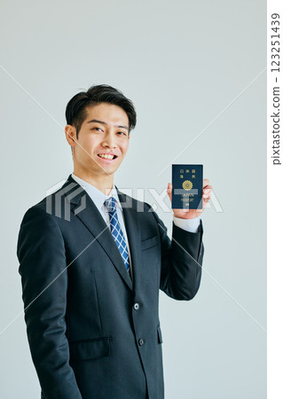 一名二十多歲的年輕人拿著護照 一名二十多歲的年輕人拿著護照 123251439