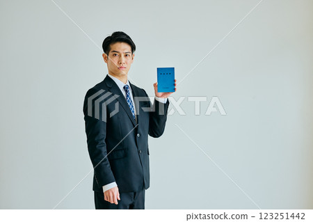 A young man in his 20s holding a pension book 123251442