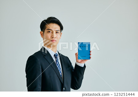 A young man in his 20s holding a pension book A young man in his 20s holding a pension book 123251444