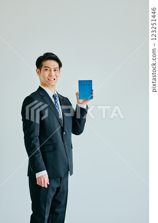 一名 20 多歲的年輕人拿著一本退休金簿 123251446