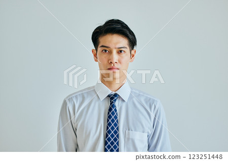 Young man in a dress shirt looking at camera on white background 123251448