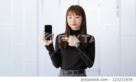 Woman/businesswoman pointing at smartphone Woman/businesswoman pointing at smartphone 123251656