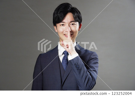 Businessman secret pose black background 123252004