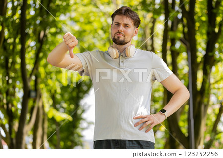 Sad upset dissatisfied loser man jogger showing thumb down bad result unmotivated disagree dislike Sad upset dissatisfied loser man jogger showing thumb down bad result unmotivated disagree dislike 123252256