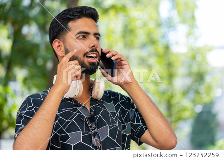 Hispanic man tourist having remote phone conversation communicate speaking by smartphone with friend 123252259
