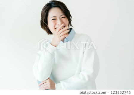 Young woman sitting on a chair in front of a wall 123252745