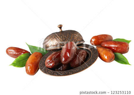 Dried dates in a bronze oriental bowl with a lid, close up, isolated on white background, PNG 123253110