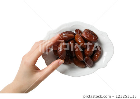Dried dates on a white saucer and hand, close up, top view, isolated on white background, PNG Dried dates on a white saucer and hand, close up, top view, isolated on white background, PNG 123253113