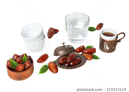 Dried dates in bronze and wooden bowl, ceramic bowls, glass of water and authentic cup of tea, isolated on white background, PNG Dried dates in bronze and wooden bowl, ceramic bowls, glass of water and authentic cup of tea, isolated on white background, PNG 123253114