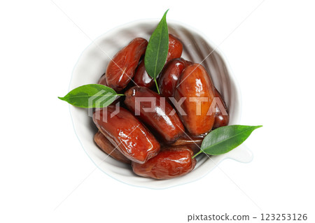 Dried dates in a white bowl, top view, isolated on white background, PNG 123253126