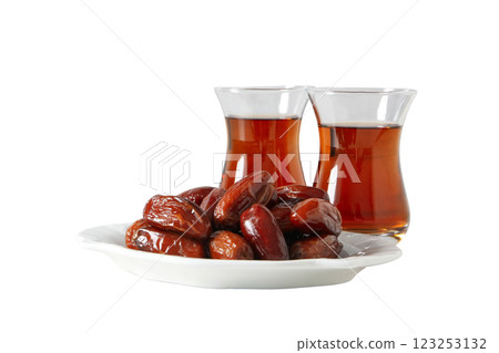 A pile of dried dates on a saucer and tea in Armudu glasses, close up, isolated on white background, PNG 123253132