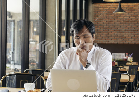 Portrait Asian Businessman typing laptop computer drinking coffee cup at office desk via wireless internet technology working online. Asian handsome man Freelance business person confident manager Portrait Asian Businessman typing laptop computer drinking coffee cup at office desk via wireless internet technology working online. Asian handsome man Freelance business person confident manager 123253173