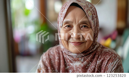Portrait of a serene senior woman wearing a hijab, radiating warmth and experience, showcasing cultural elegance in a modern setting. 123253820
