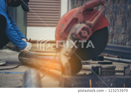 Construction Worker hands using Welding machinery iron metal sparking. Men hands wear protective glove Hot flame metal work cutting fire iron workshop. Locksmith use Welding machine cut metal process 123253970