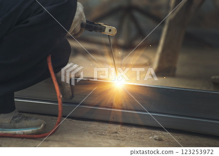 Construction Worker hands using Welding machinery iron metal sparking. Men hands wear protective glove Hot flame metal work cutting fire iron workshop. Locksmith use Welding machine cut metal process Construction Worker hands using Welding machinery iron metal sparking. Men hands wear protective glove Hot flame metal work cutting fire iron workshop. Locksmith use Welding machine cut metal process 123253972