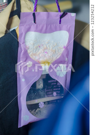 Purple hanging moisture absorber bag collecting humidity in a closet space. High quality photo 123254212