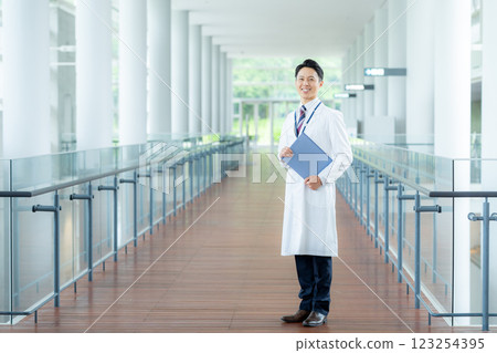 A man in a white coat working in a medical facility A man in a white coat working in a medical facility 123254395
