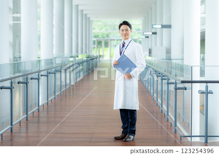 A man in a white coat working in a medical facility A man in a white coat working in a medical facility 123254396