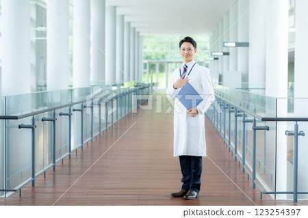 A man in a white coat working in a medical facility A man in a white coat working in a medical facility 123254397