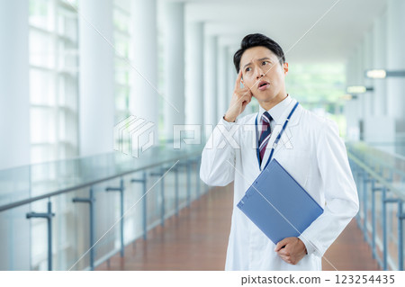 一名身穿白大褂的男子在醫療院所工作 123254435