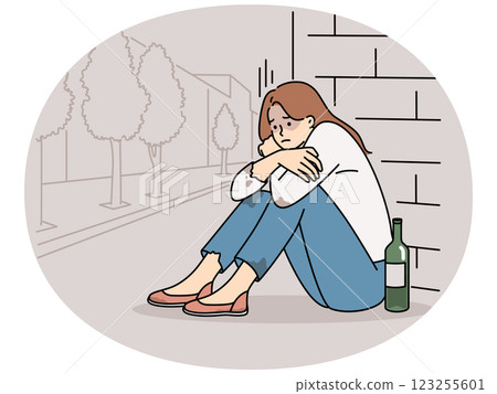 Female addict sit on ground with wine bottle 123255601