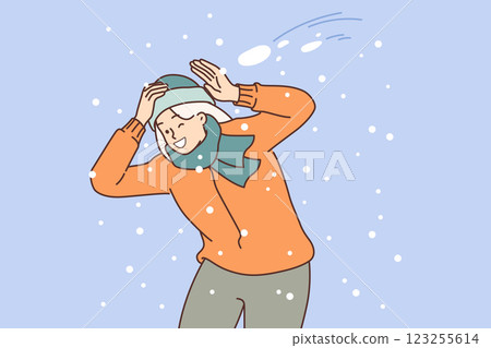 Happy woman plays snowball and dodges snow flying at head, rejoicing in arrival of winter days 123255614