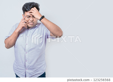Exhausted person putting the palm of his hand on his face. Fatigued and exhausted man isolated. Concept of a bored and tired man 123256568