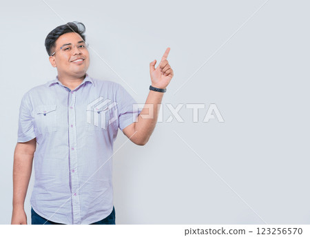 Happy latin man pointing a space to the side isolated. Smiling people pointing a banner to the side Happy latin man pointing a space to the side isolated. Smiling people pointing a banner to the side 123256570