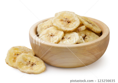 Dried banana chips in a wooden plate and pieces on a white background. Isolated Dried banana chips in a wooden plate and pieces on a white background. Isolated 123256635