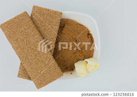 Close-up of a white plate with liver pate and slices of butter, bread on top on a white background in the center. The concept of snacks, healthy food, diet. High quality photo 123256818