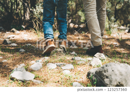 Close-up rear view of tourists school boy and his dad walking a stone footpath in spring forest. Child boy and father wearing casual clothes while hiking in summer greenwood forest Close-up rear view of tourists school boy and his dad walking a stone footpath in spring forest. Child boy and father wearing casual clothes while hiking in summer greenwood forest 123257360