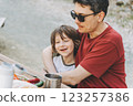 Close-up view of father hugs his school boy son on a family picnic in the mountains. Child kid and his dad taking a rest and enjoying a picnic while hiking in the mountains 123257386