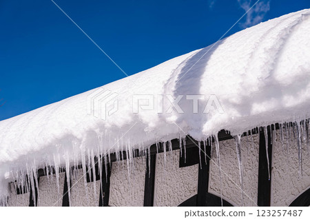 Icicles growing from snow on the roof 123257487