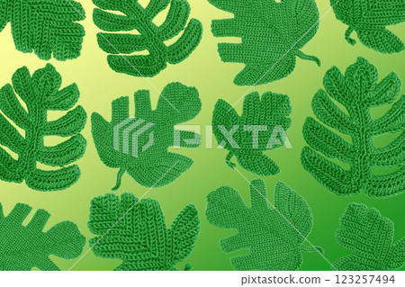 Spring abstract background of knitted green leaves of monstera. Leaf pattern. Hobbies of knitting toys and home decorations. Banner, flat lay, copy space 123257494