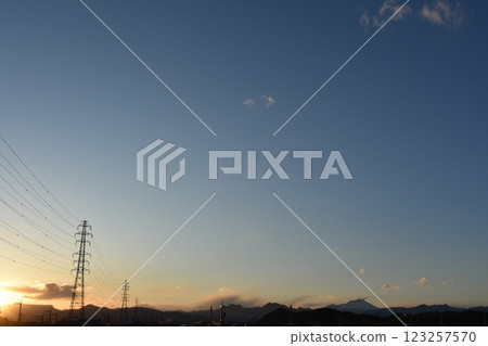 Power lines and towers visible beyond the mountains at dusk 123257570