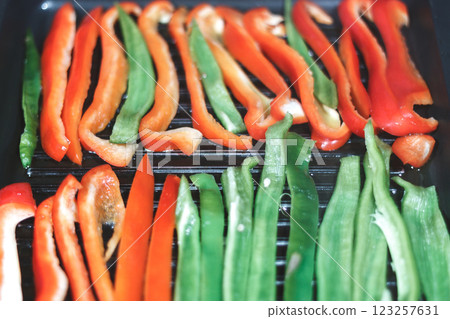 Sliced Red and Green Peppers on Grill for Cooking 123257631