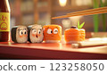 A colorful display of cartoon sushi pieces on a wooden table. The sushi features cute, expressive faces and is accompanied by chopsticks and a bottle of soy sauce. Bright colors dominate the scene. 123258050