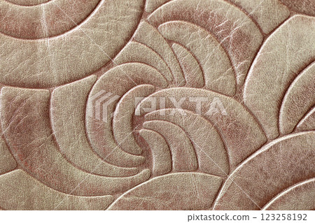 Embossed leather texture with an elegant abstract pattern of curved shapes. Luxury design, fashion, upholstery applications. High-end craftsmanship, decorative leather accessory concept Embossed leather texture with an elegant abstract pattern of curved shapes. Luxury design, fashion, upholstery applications. High-end craftsmanship, decorative leather accessory concept 123258192