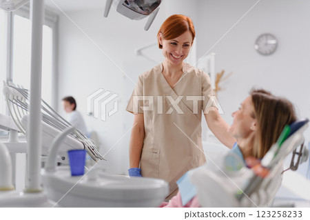 Female dentist talking to patient in dental clinic during anual check-up. 123258233