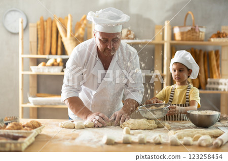 Bakers dad teaches his daughter niece to knead dough 123258454